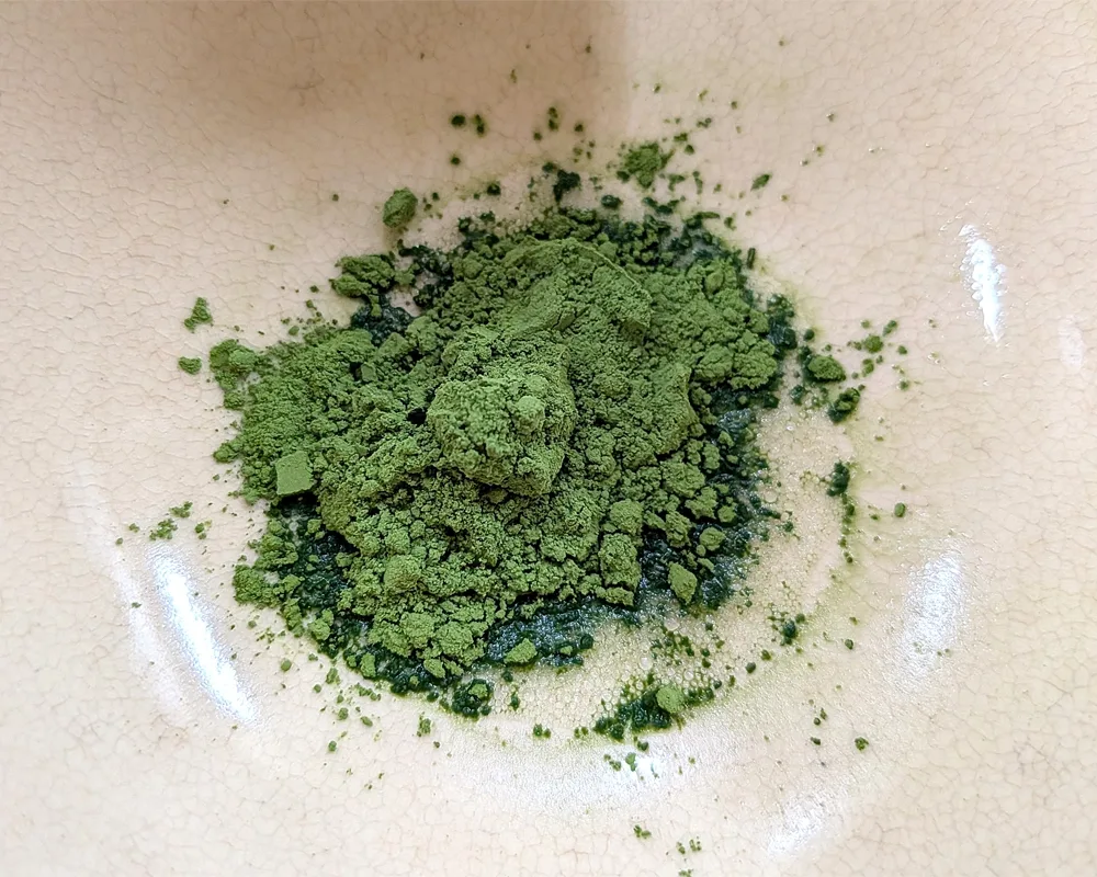 Green powder in a tea cup.