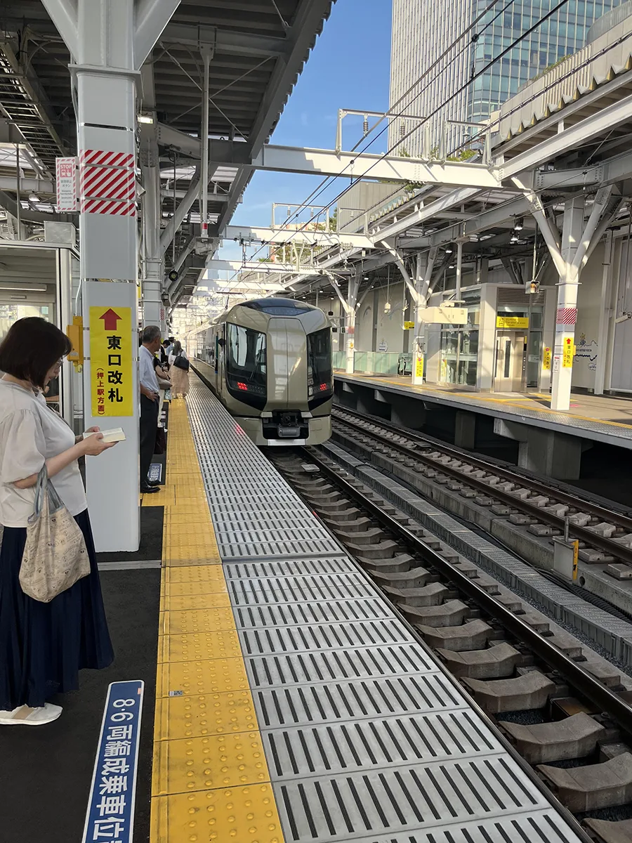 A train enters an above-ground, outdoor station in Tokyo, Japan.