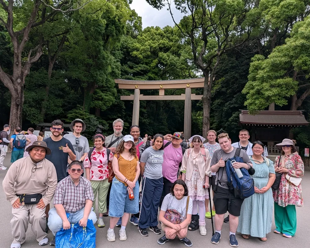 A group of students standing in front of a torii gate.