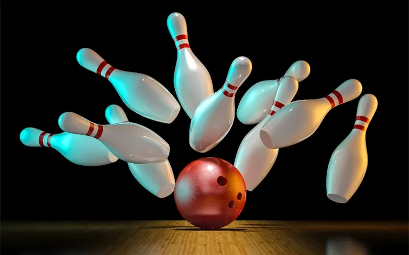 Bowling pins being hit by a rust-colored bowling ball.