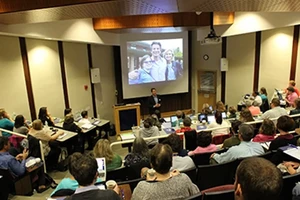 An auditorium full of people listening to a presentation.