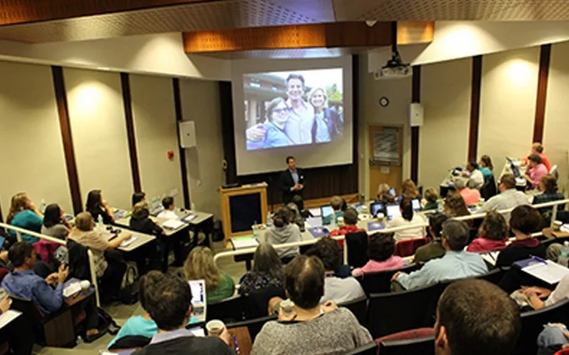 An auditorium full of people listening to a presentation.