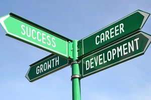 A green road sign showing the words success, growth and career development.