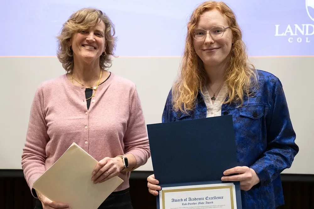 A professor Rebecca Matte standing to the left of award recipient Rachel Schmidt.