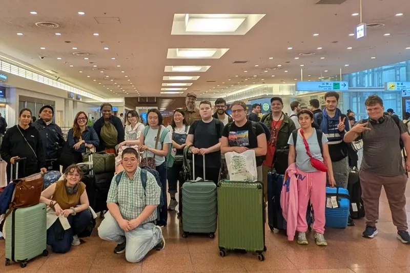 A group of students and their luggage at an airport.