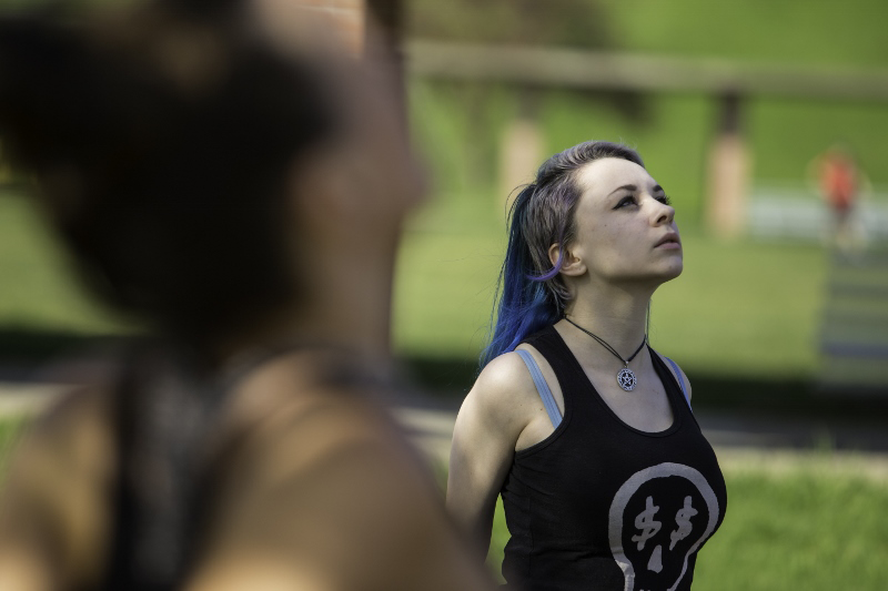 Student looks upward while stretching during yoga class outdoors