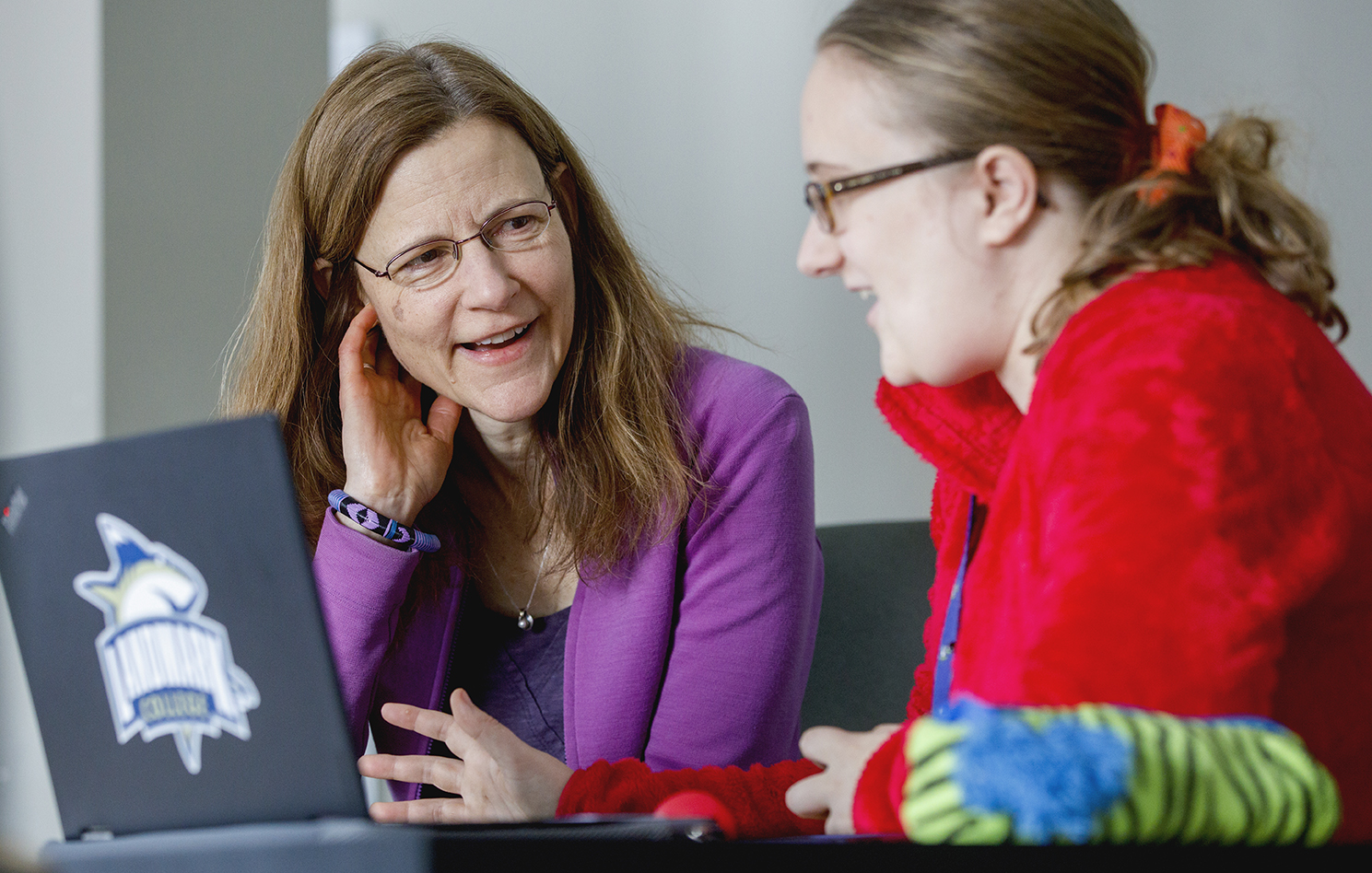 A Landmark College professor works with a student on a laptop computer.