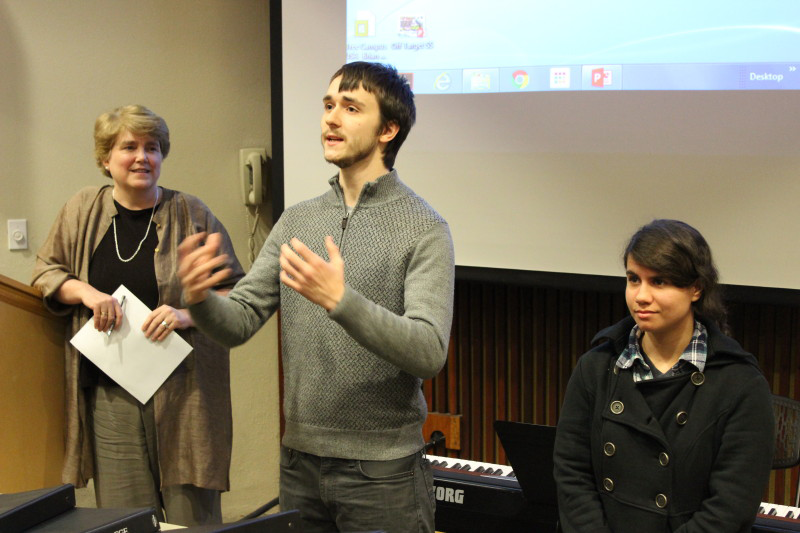 Dr. Gail Gibson Sheffield looks on as a student gestures and a second student looks on.