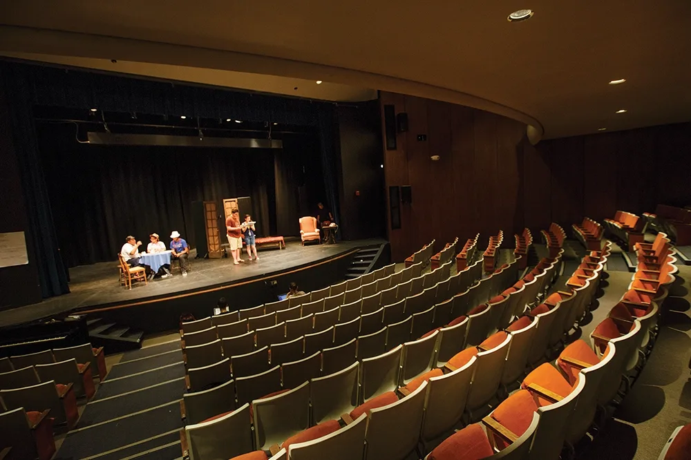 A view of the empty FAB theatre with a few people on stage.