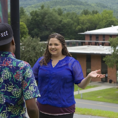 Rachel Brown standing on upper campus talking to another person