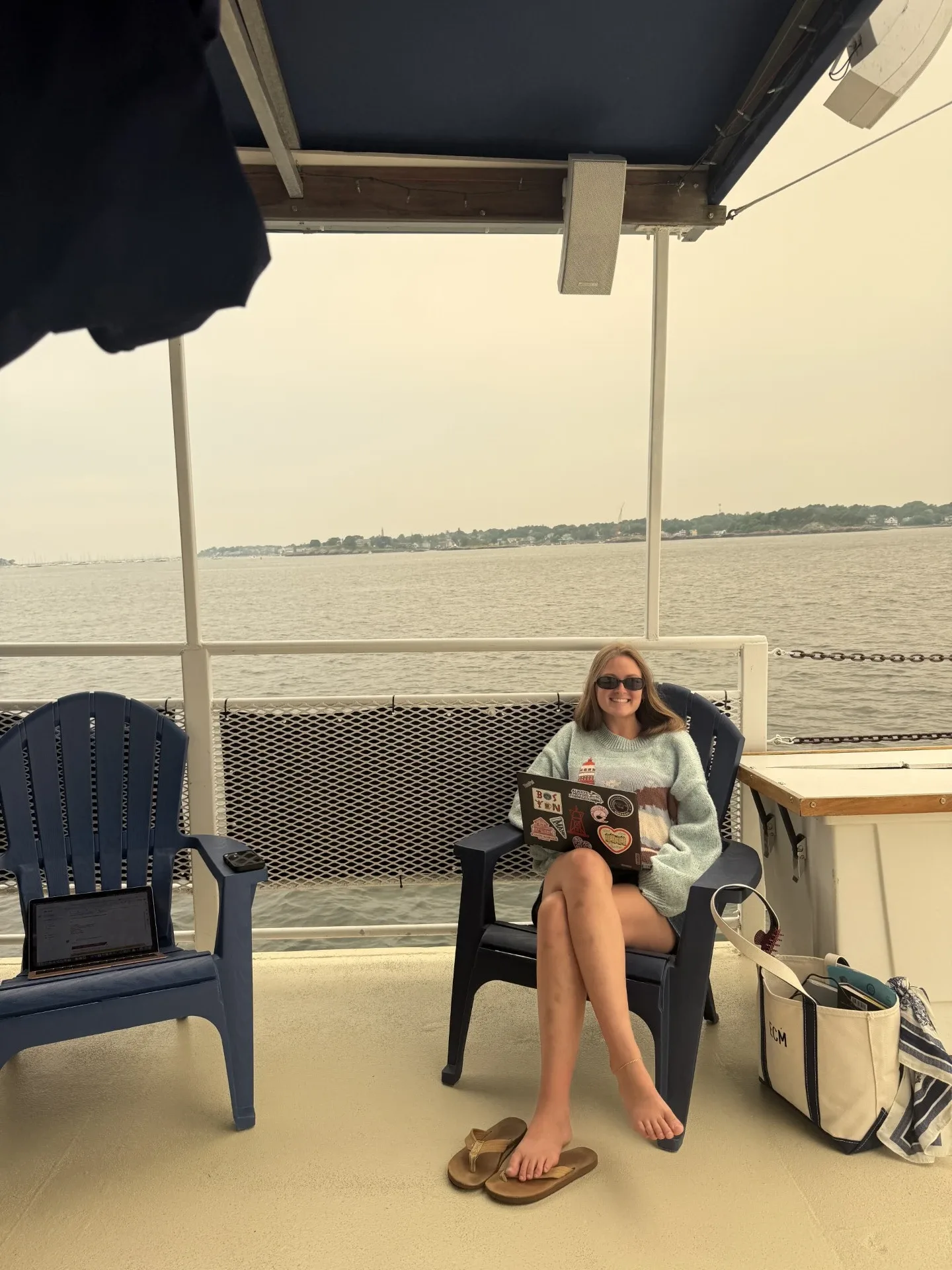 A photo of LC student intern Ellie Matte sitting with her laptop aboard a Mahi Cruise in the Atlantic Ocean off Salem, MA.