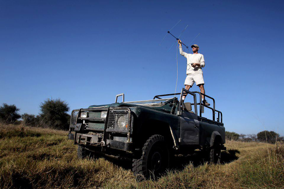 Andrew Stein stands atop an all-terrain vehicle holding a large antenna.