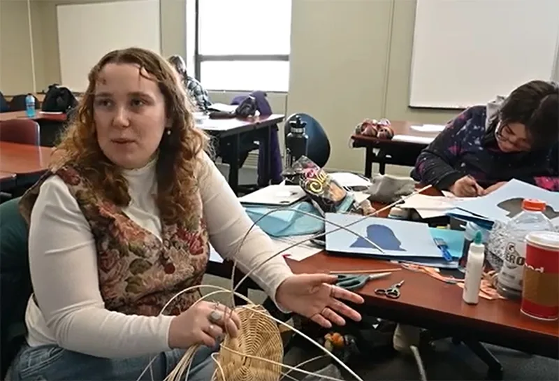 A woman weaving a basket.