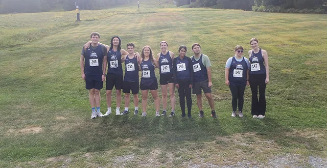 Landmark College's Running Team posing for a photo in a field.