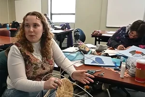 A woman weaving a basket.