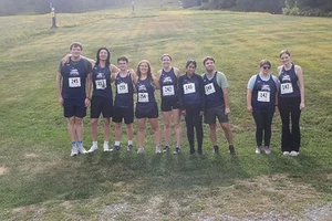Landmark College's Running Team posing for a photo in a field.