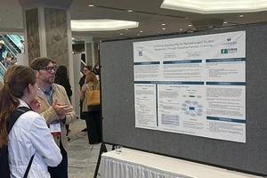Dr. Rick Bryck standing with a conference participant in front of a poster.