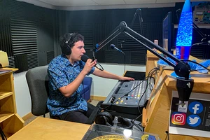 A student on-air in the WLMC radio station.
