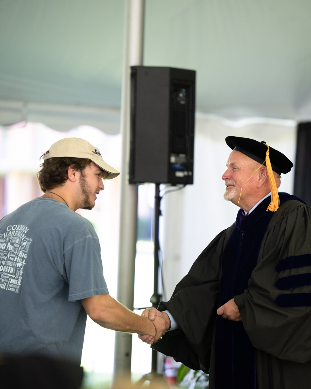 The Interim President shaking hands with a student