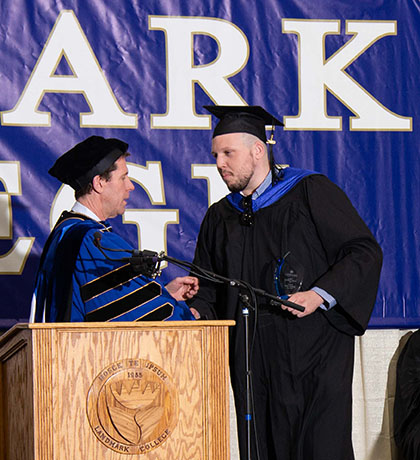 Connor Lawrence shakes hands with Landmark College president Dr. Peter Eden after accepting the President's Award during the 2019 Spring Commencement ceremony.