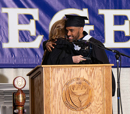 Isaac Alam shares and embrace with Dean of Students Kelly O'Ryan after accepting the Community Service Award during the 2019 Spring Commencement ceremony.
