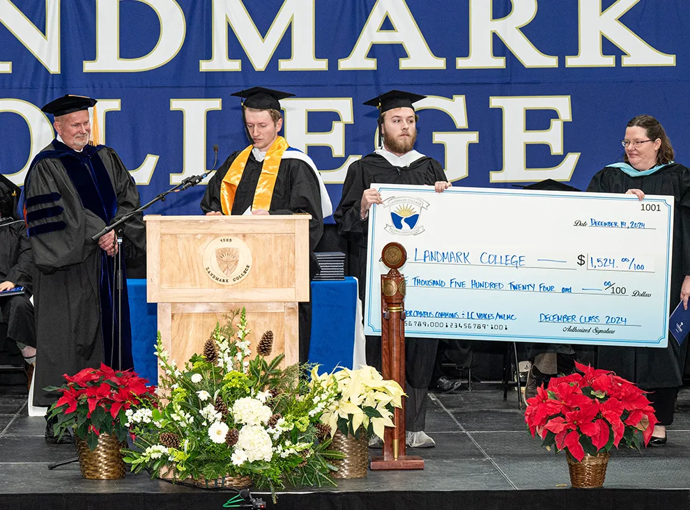 Student Will Donohue at podium making remarks with Interim President Dr. Jim Dlugos and stude