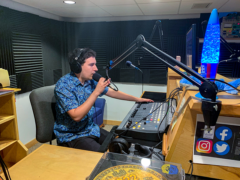 A student on-air in the WLMC radio station.