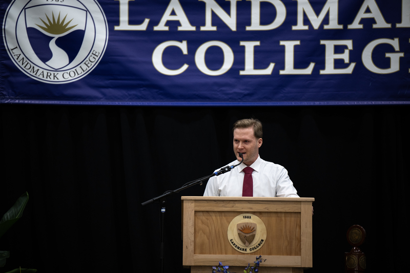 Man wearing white shirt and necktie making remarks at podium.