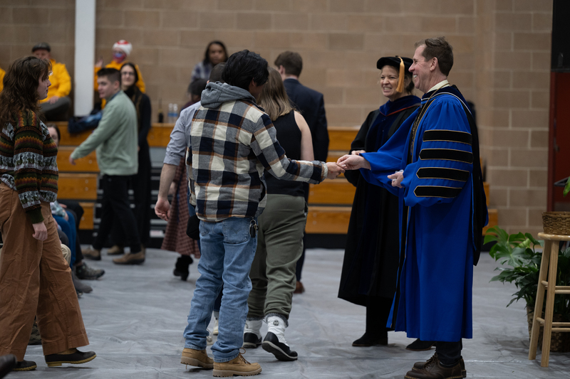 Students coming forward to received coins from Dr. Eden and Dr. Kalich.