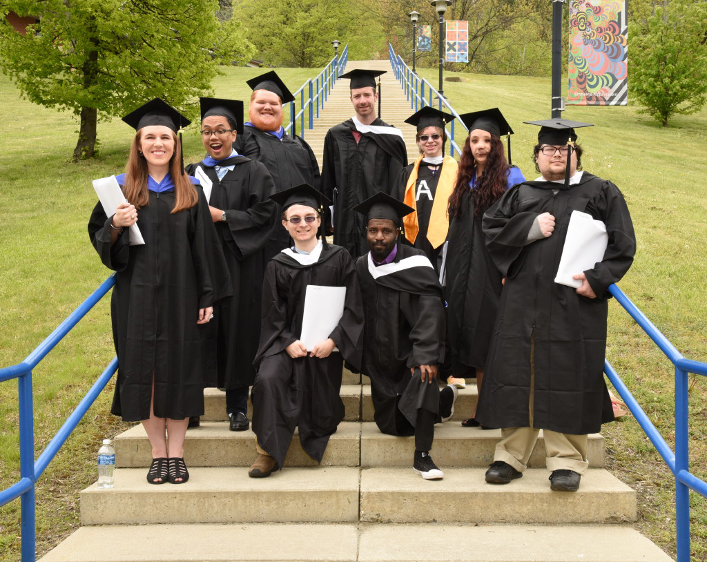 Students in academic regalia standing on steps to upper campus.