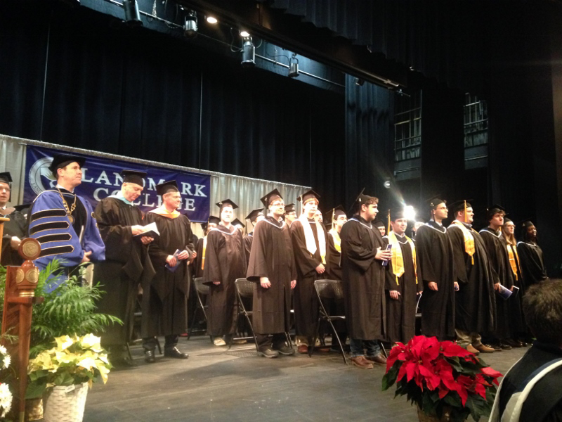 Senior administrators and graduates stand on the stage at the start of the ceremony.
