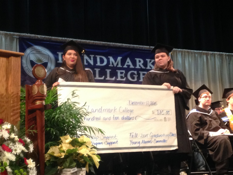 Two students hold an oversized check representing the class gift.