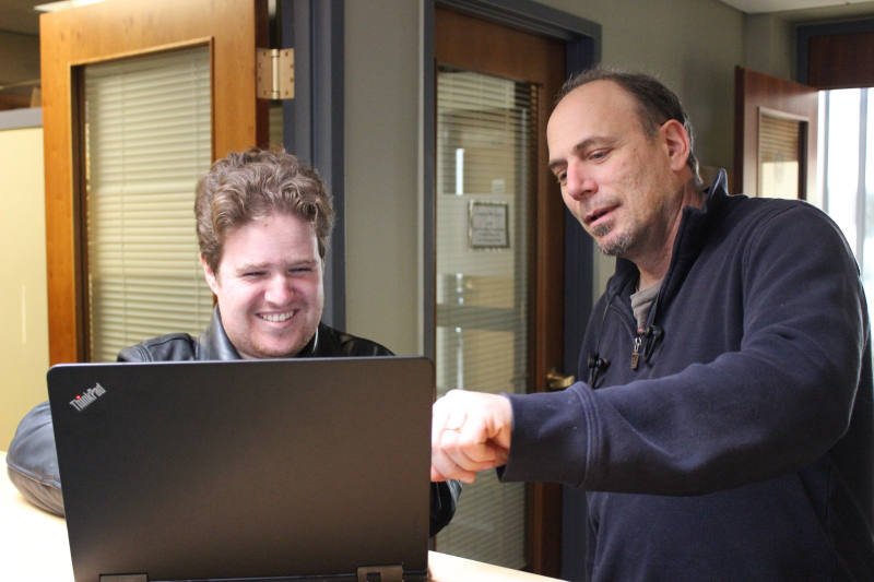 Jackson Hunter looks at computer with Landmark College webmaster.