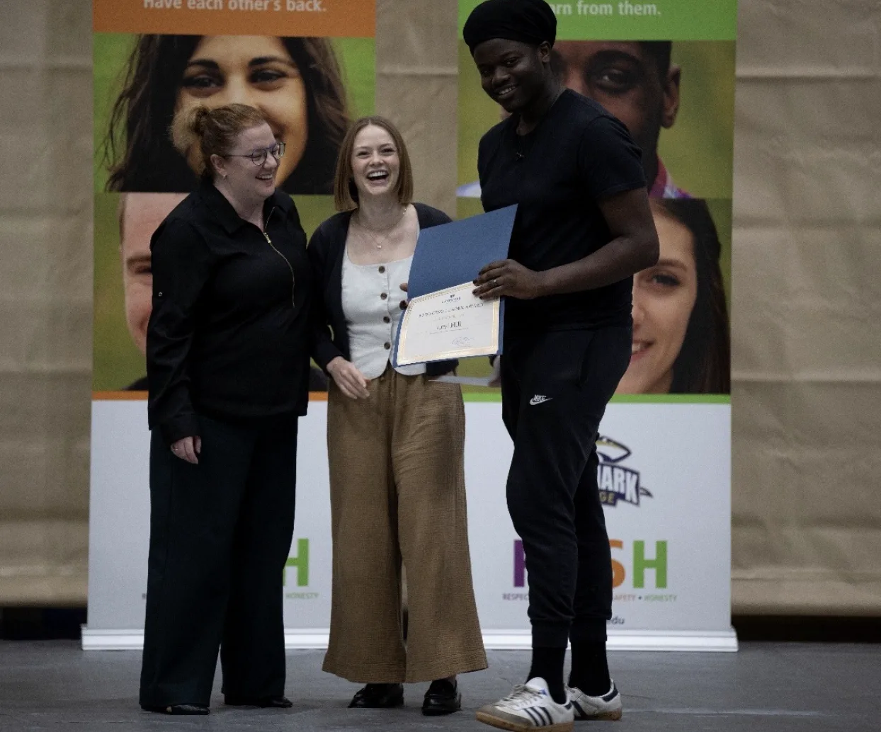 Levi Hill standing to the right of presenters Erica Loveland and Sydney Ruff on the far left.