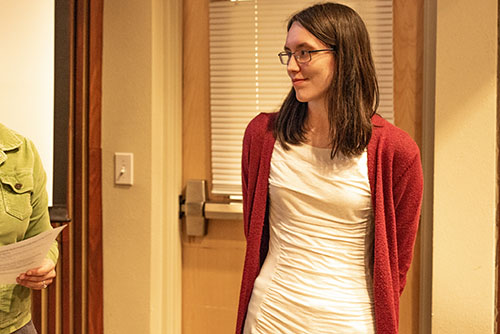 Sarah Lennox wearing a white dress and red cardigan.