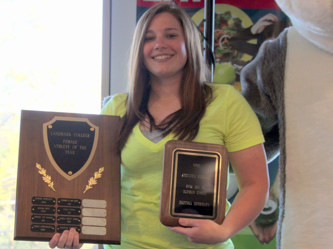 Student holding two plaques.