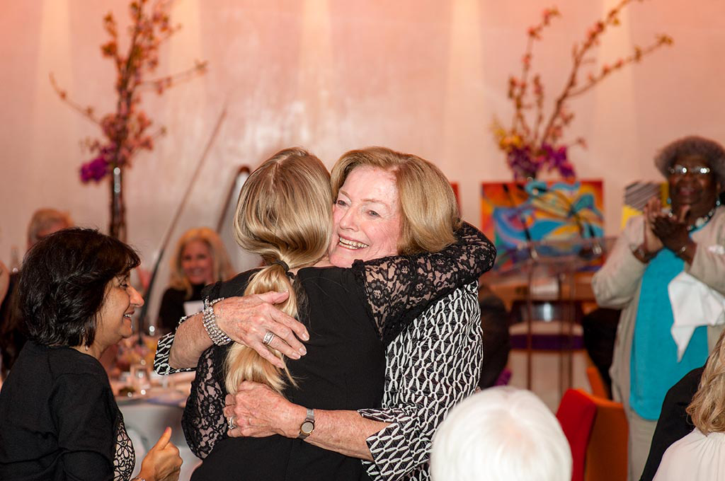 Two women hugging each other.