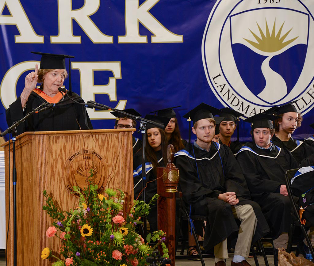 Nan standing at the podium giving a speech with her hand in the air.
