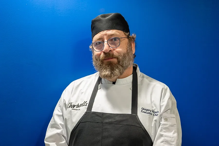 Gregory Roach, an executive chef for Chartwells Higher Ed, poses for a photo against a plain background.