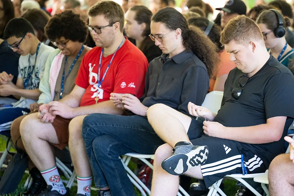 A group of new students look down at their Landmark Coins at a Convocation Ceremony.