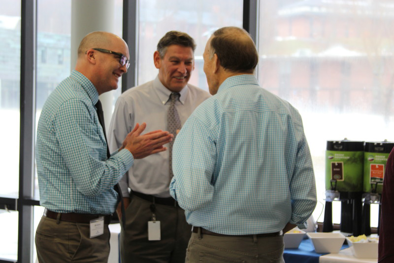 Three superintendents stand and talk in Cafe Court at Landmark College.